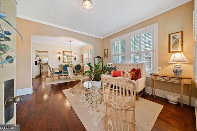 sitting room with ornamental molding, an inviting chandelier, and dark hardwood / wood-style flooring