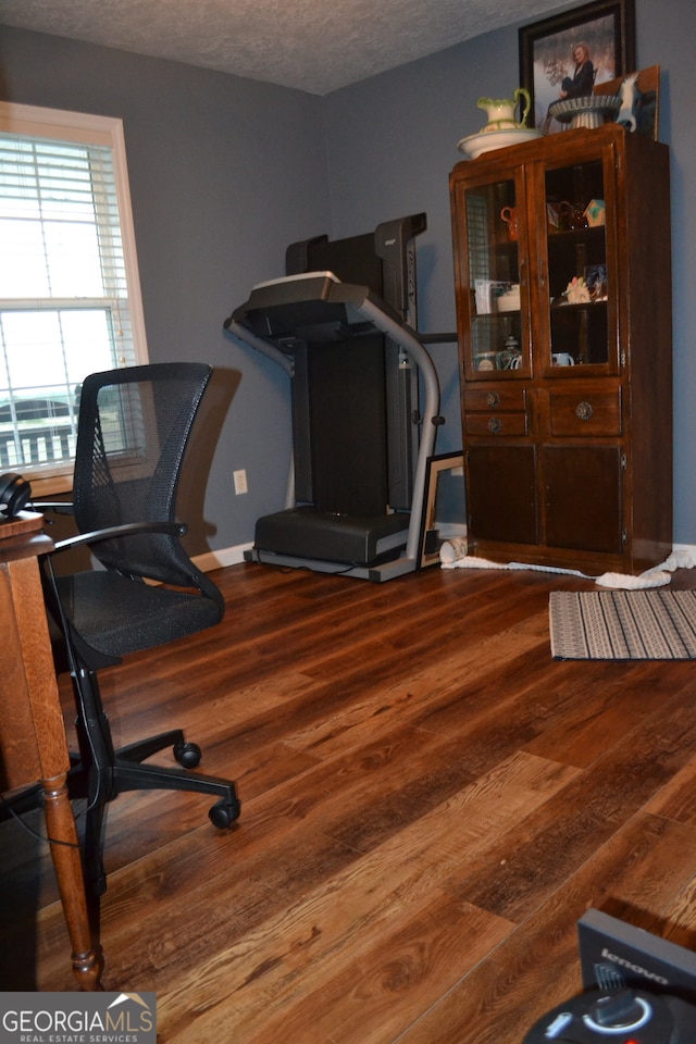 office area with hardwood / wood-style floors and a textured ceiling