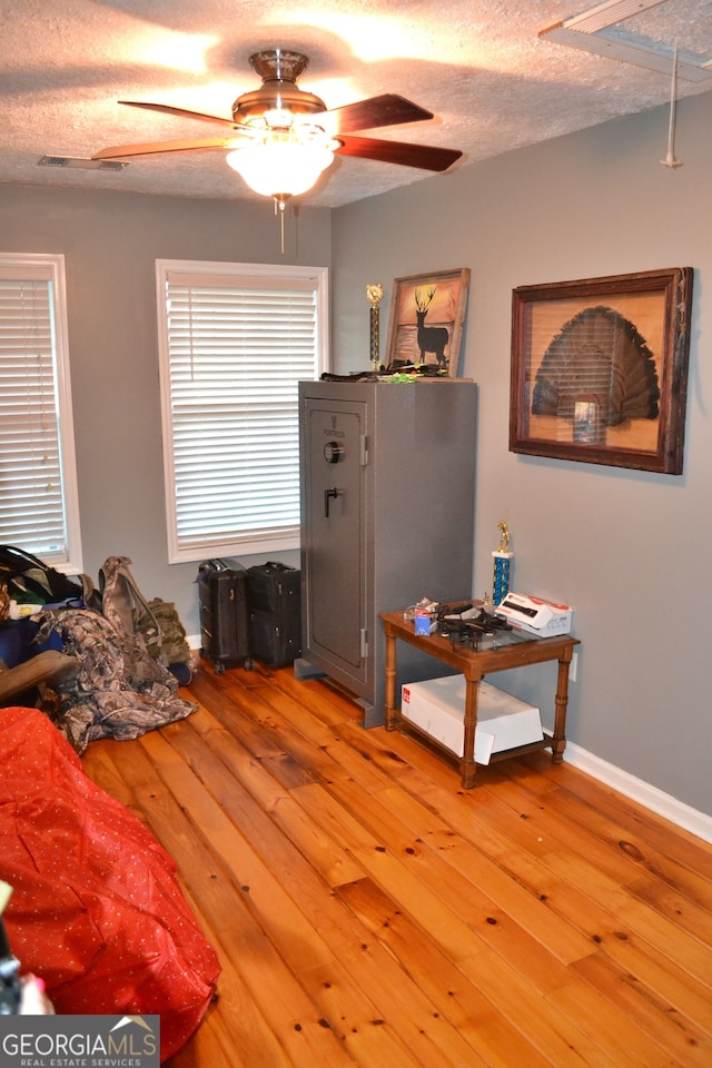 bedroom with wood-type flooring, a textured ceiling, and ceiling fan