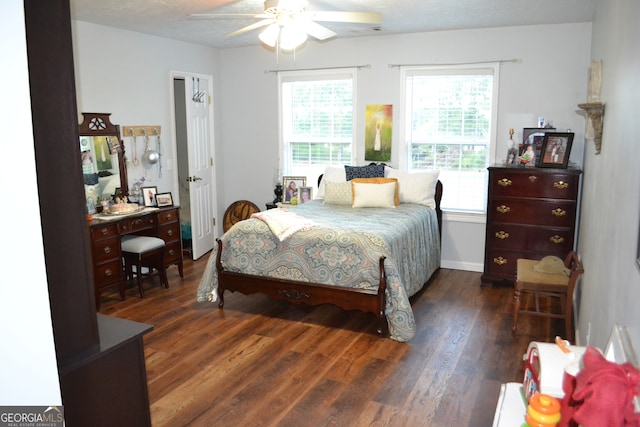 bedroom with ceiling fan, dark wood-type flooring, and a textured ceiling