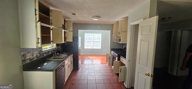 kitchen with stainless steel stove, tasteful backsplash, sink, black dishwasher, and light tile patterned floors