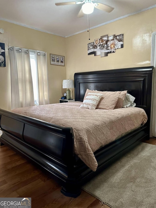 bedroom featuring ceiling fan, dark hardwood / wood-style floors, and ornamental molding