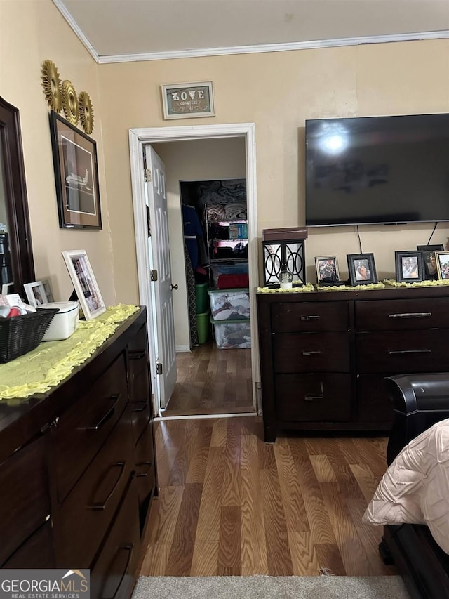 bedroom featuring ornamental molding, a closet, and dark hardwood / wood-style flooring