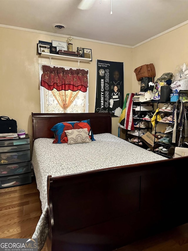 bedroom featuring ceiling fan, hardwood / wood-style flooring, and ornamental molding