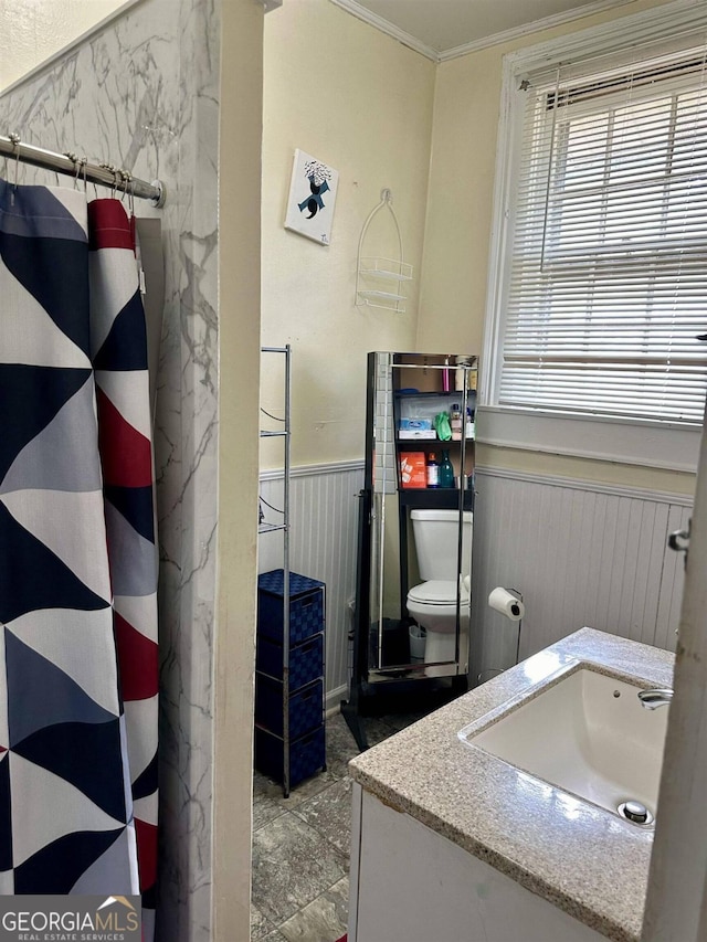 bathroom with walk in shower, vanity, crown molding, and toilet