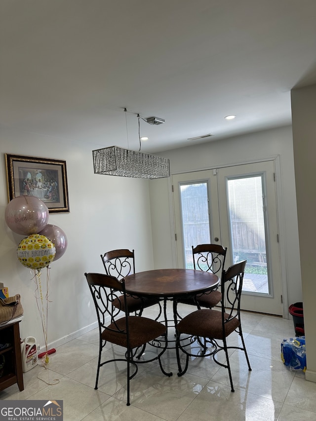 dining space featuring french doors and light tile patterned floors