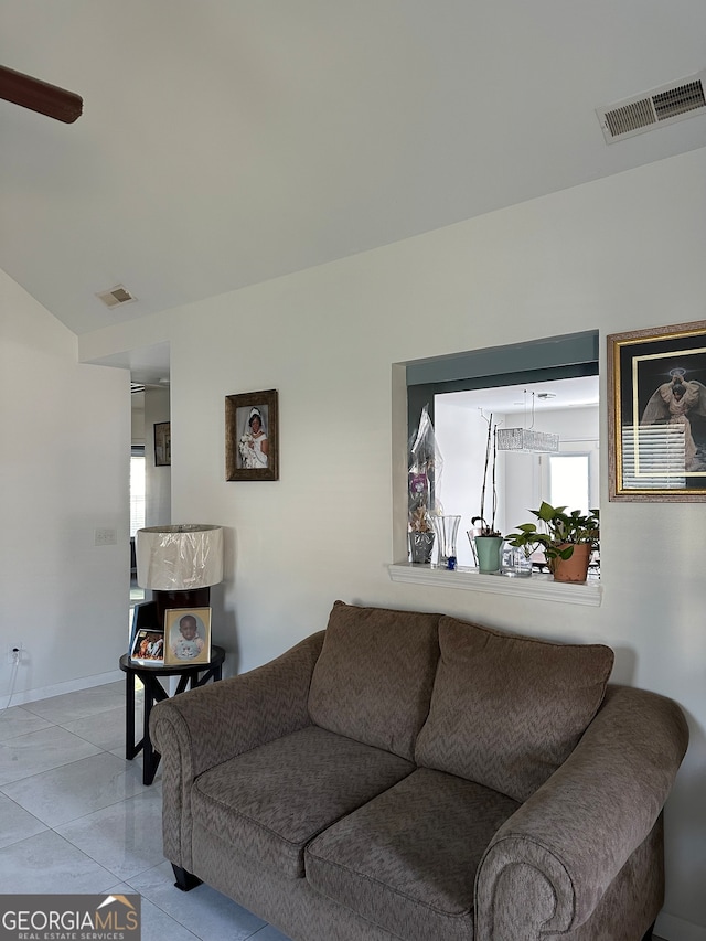 tiled living room with ceiling fan and plenty of natural light