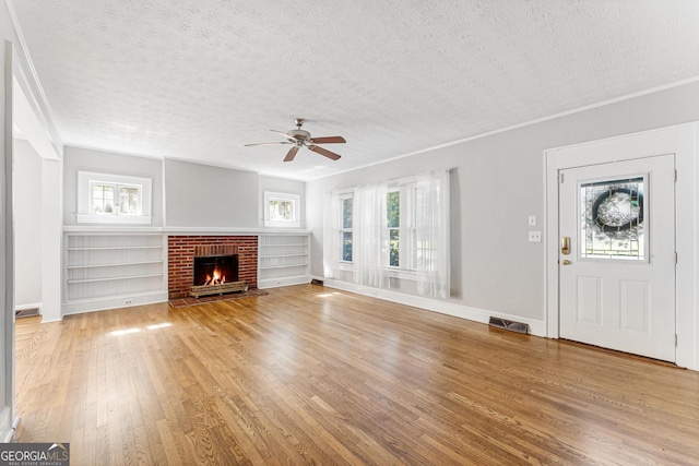 unfurnished living room featuring a fireplace, hardwood / wood-style floors, and a textured ceiling