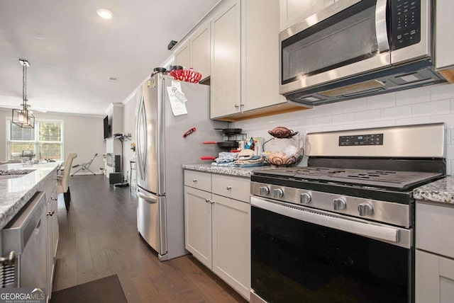 kitchen with stainless steel appliances, light stone countertops, white cabinets, and dark hardwood / wood-style flooring