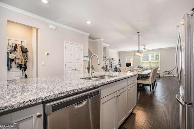 kitchen featuring light stone countertops, dark hardwood / wood-style floors, sink, ornamental molding, and appliances with stainless steel finishes