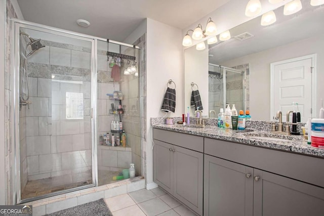 bathroom with tile patterned flooring, walk in shower, and vanity