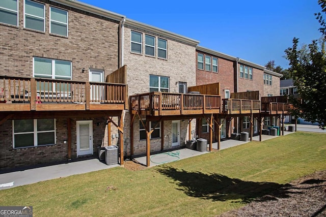 back of property featuring a patio area, a wooden deck, a lawn, and cooling unit