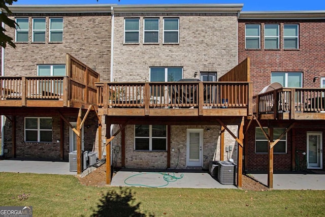 rear view of property featuring a deck, a yard, and a patio