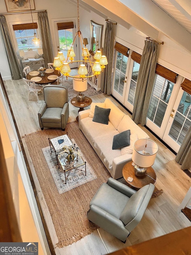 living room featuring light hardwood / wood-style flooring, french doors, and vaulted ceiling