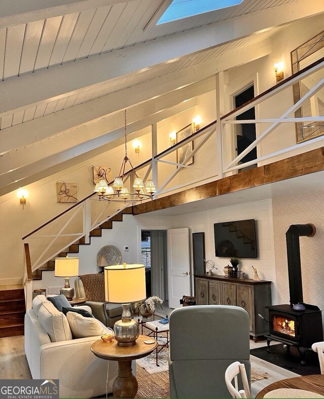 living room featuring wood ceiling, high vaulted ceiling, a notable chandelier, beamed ceiling, and light wood-type flooring