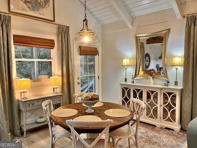 dining space featuring hardwood / wood-style flooring, vaulted ceiling with beams, and wood ceiling