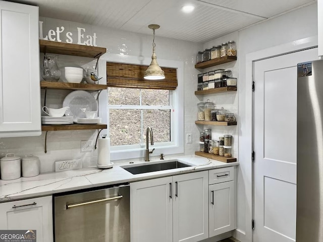 kitchen featuring decorative light fixtures, dishwasher, sink, white cabinets, and fridge