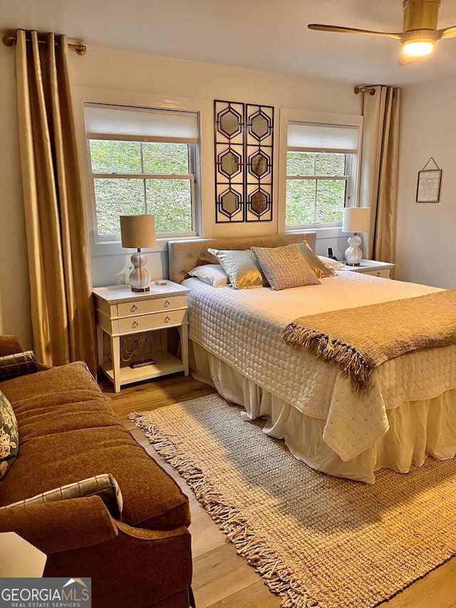 bedroom with ceiling fan, hardwood / wood-style floors, and multiple windows