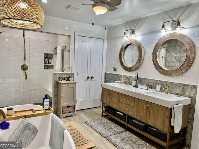 bathroom featuring ceiling fan, wood-type flooring, tile walls, and vanity