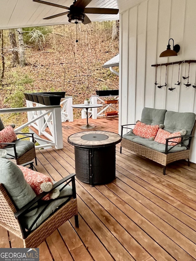 deck with ceiling fan and an outdoor fire pit