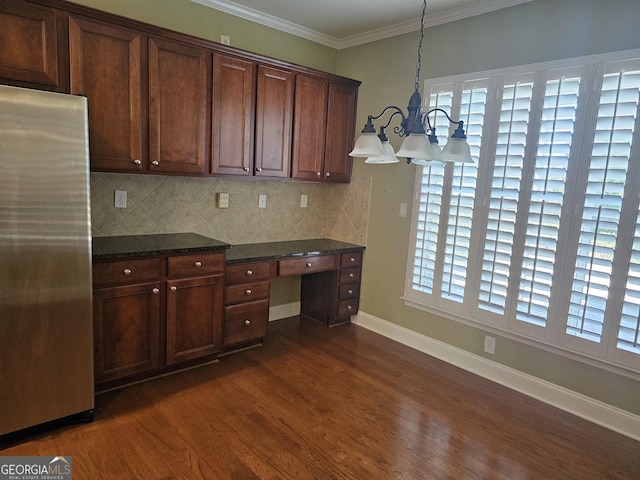 5911 Chimney Rock Dr, Hoschton, GA 30548 - kitchen with backsplash, dark wood finished floors, built in desk, freestanding refrigerator, and a notable chandelier