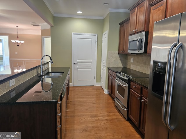 5911 Chimney Rock Dr, Hoschton, GA 30548 - kitchen featuring ornamental molding, a sink, dark stone countertops, appliances with stainless steel finishes, and a notable chandelier