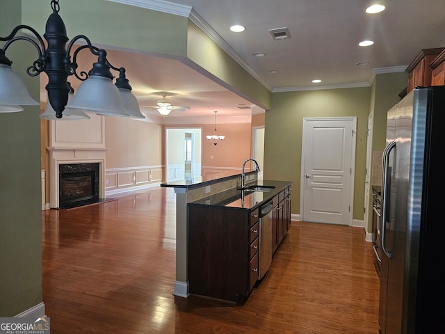 kitchen featuring pendant lighting, sink, dark wood-type flooring, stainless steel appliances, and crown molding