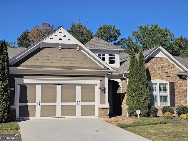 5911 Chimney Rock Dr, Hoschton, GA 30548 - view of front of property with an attached garage, driveway, a shingled roof, and stone siding