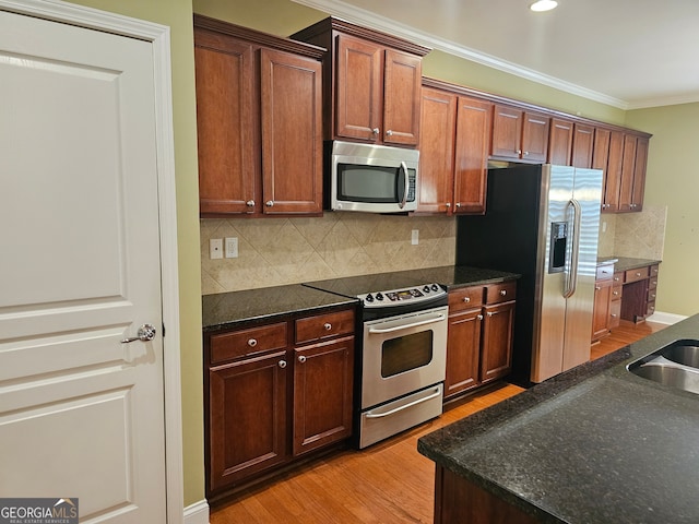 kitchen with stainless steel appliances, light wood-type flooring, ornamental molding, and tasteful backsplash