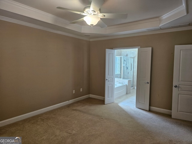 unfurnished bedroom with ornamental molding, light colored carpet, ceiling fan, and a raised ceiling