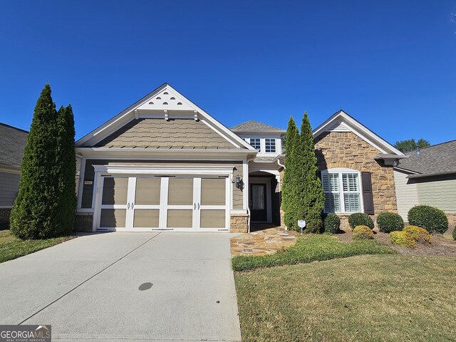 5911 Chimney Rock Dr, Hoschton, GA 30548 - craftsman-style home with an attached garage, a front yard, stone siding, and concrete driveway