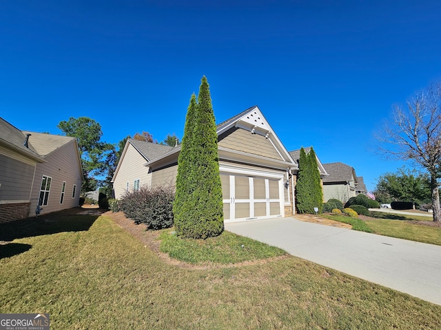 view of side of home featuring a garage and a yard