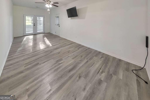 83 Sunset Ln, Newnan, GA 30263 - unfurnished living room with french doors, baseboards, a ceiling fan, and wood finished floors