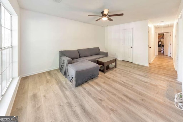 living room with light hardwood / wood-style flooring and ceiling fan