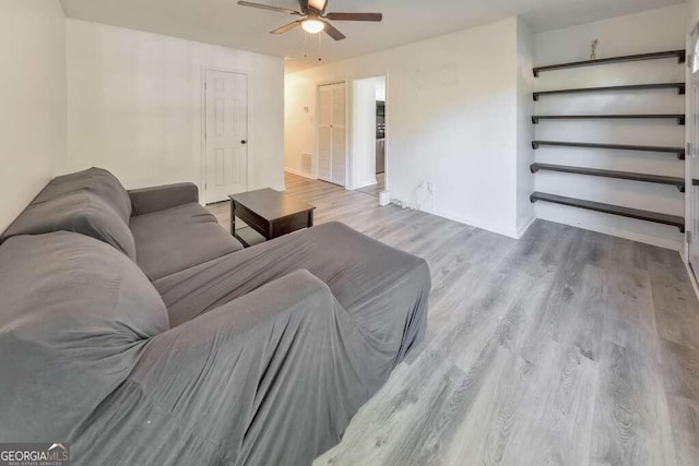 living room featuring ceiling fan and light wood-type flooring