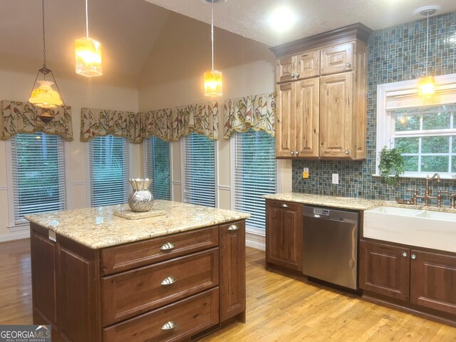 kitchen featuring hanging light fixtures, vaulted ceiling, stainless steel dishwasher, and sink