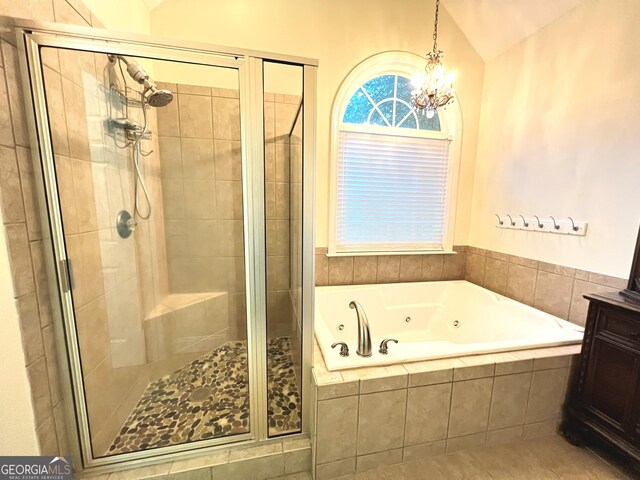 bathroom with vanity, tile patterned flooring, vaulted ceiling, and plus walk in shower