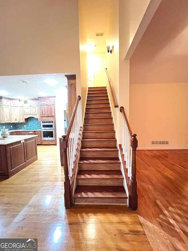 stairway with hardwood / wood-style flooring