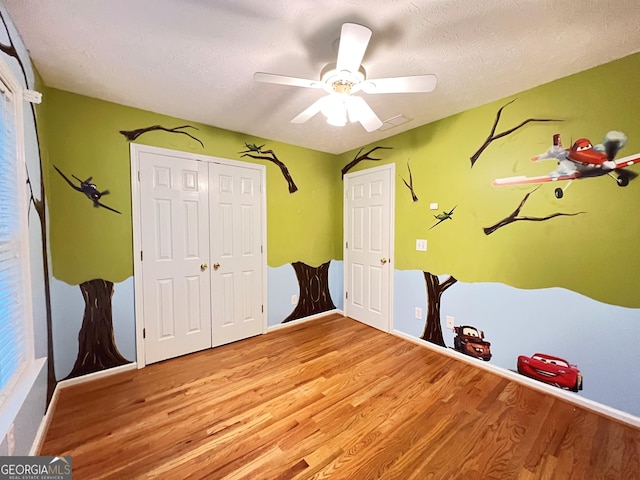 unfurnished bedroom with a closet, light hardwood / wood-style floors, and a textured ceiling