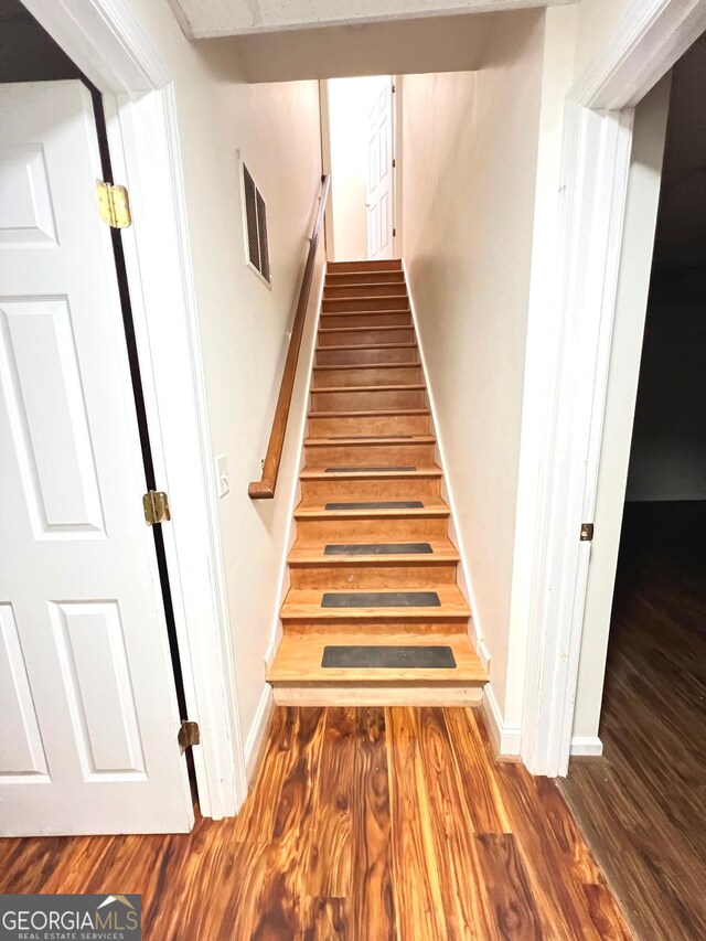 staircase featuring wood-type flooring