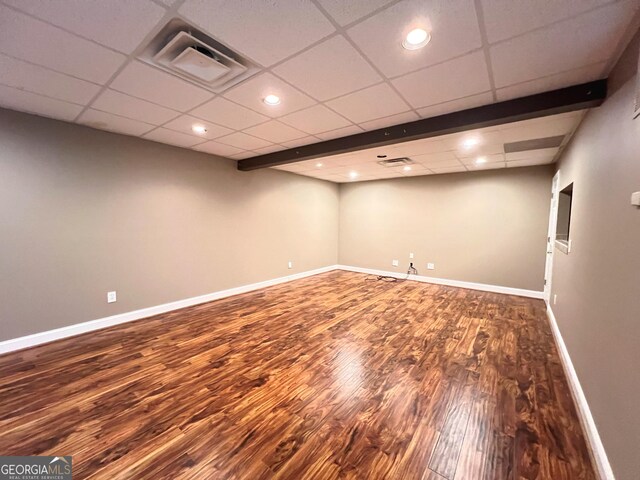 basement featuring a paneled ceiling and hardwood / wood-style floors