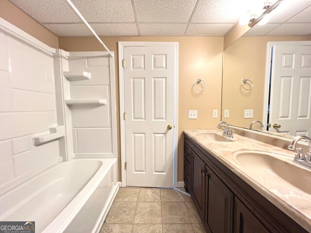 bathroom with tile patterned floors, vanity, shower / bathtub combination, and a drop ceiling