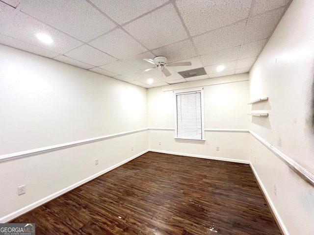 unfurnished room featuring hardwood / wood-style floors, a drop ceiling, and ceiling fan