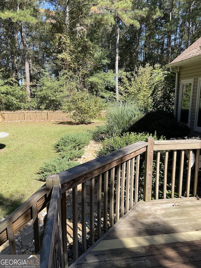 wooden deck featuring a lawn