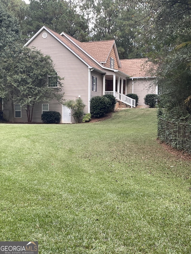 view of property exterior with covered porch and a lawn