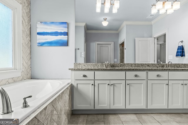 bathroom featuring ornamental molding, a healthy amount of sunlight, a relaxing tiled tub, and vanity