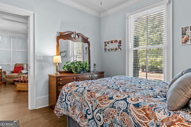 bedroom featuring hardwood / wood-style flooring, crown molding, and multiple windows