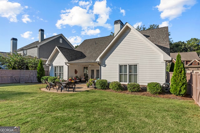 rear view of house featuring a yard and a patio