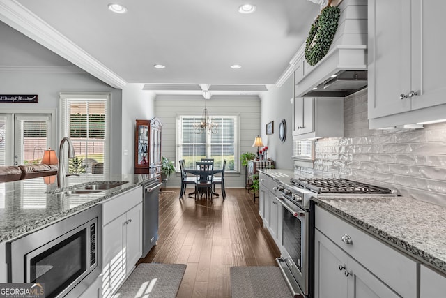 kitchen featuring appliances with stainless steel finishes, sink, ornamental molding, and dark hardwood / wood-style flooring