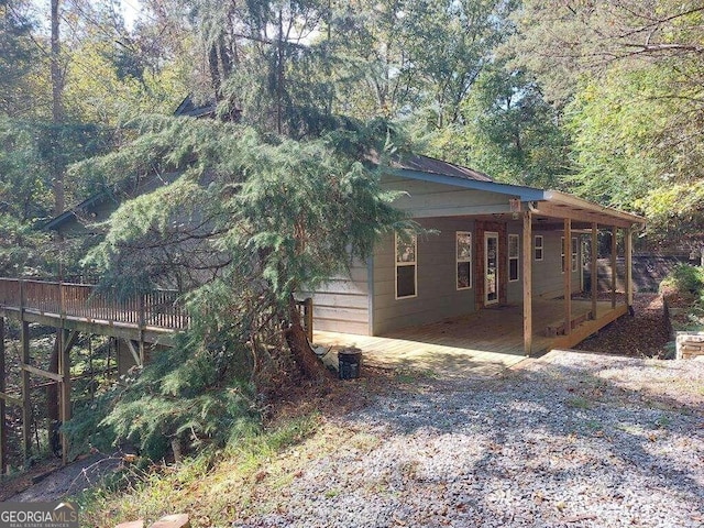 view of property exterior featuring a patio and a deck